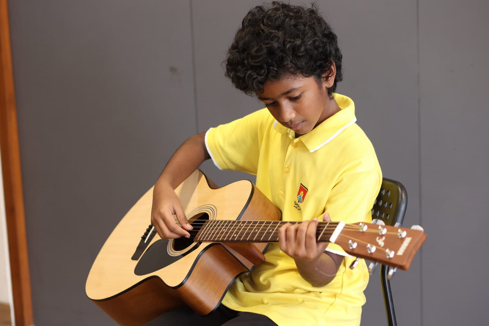 A Shikha Academy student practising guitar in a creative learning space